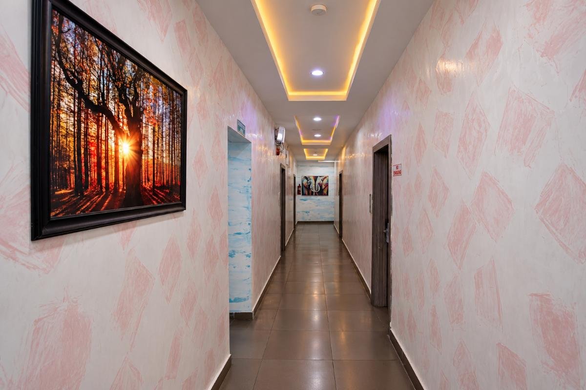 Modern hotel corridor with illuminated ceiling, guest room doors and decorative wall artwork at PEB Global Hotel