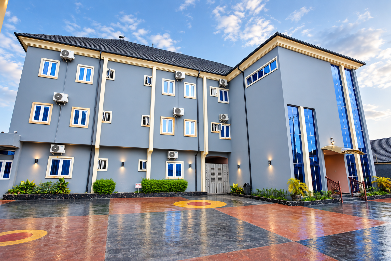 Exterior view of PEB Global Hotel Jeddo featuring a modern grey facade, glass entrance and landscaped grounds