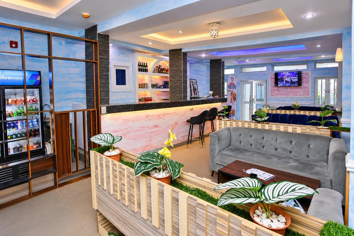 Modern hotel lounge and bar area with comfortable seating, decorative plants, and stylish interior lighting.